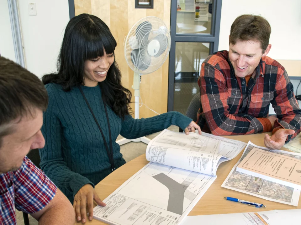 Engineers reviewing technical drawings together at a desk