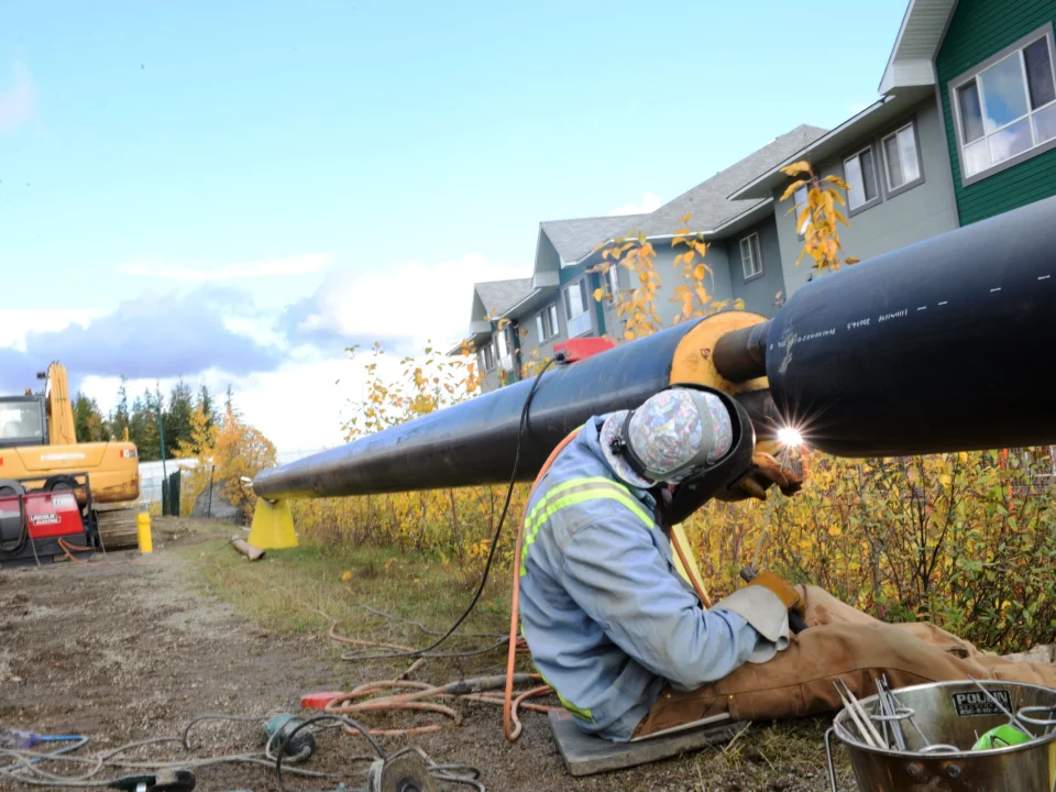Welder working on a large-diameter pipeline in the field