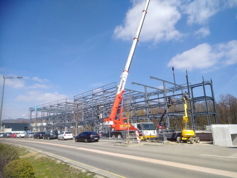 Mobile crane erecting a steel-framed building